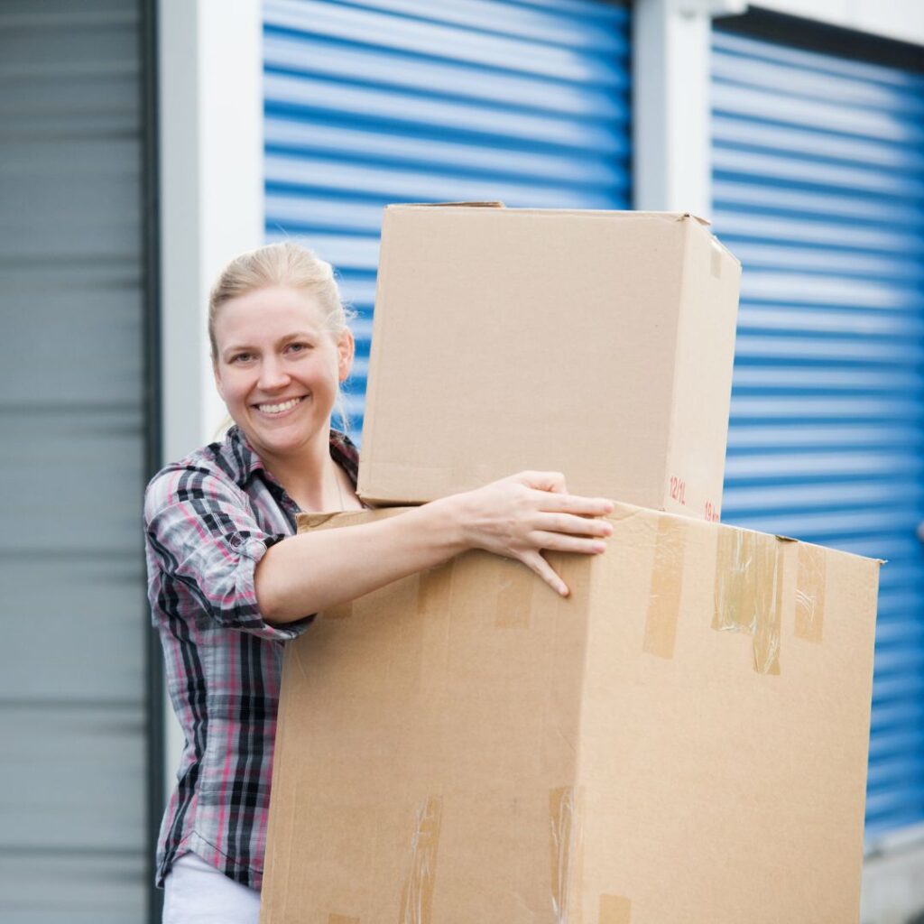 Woman carrying boxes out of a storage unit. 